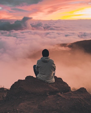 Homme qui médite devant des nuages